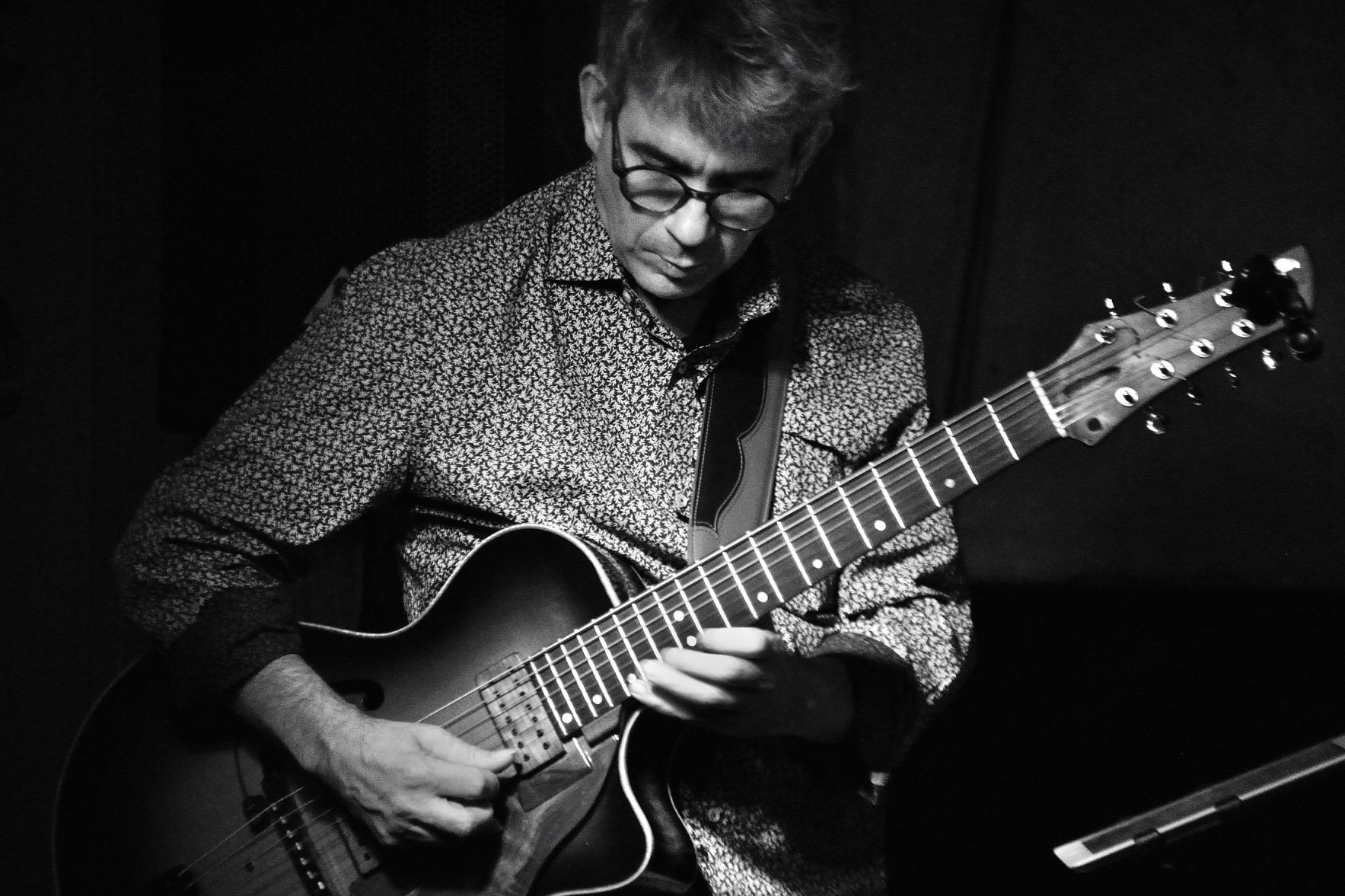 Later Dan Rochlis playing guitar in black and white