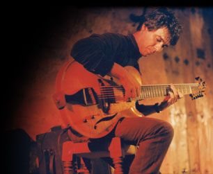 Dan Rochlis playing guitar in a candid photo